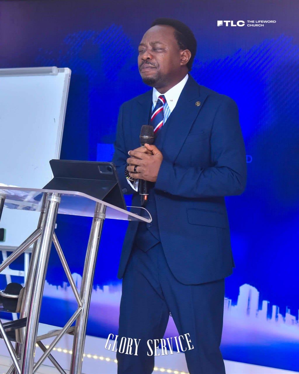 Pastor Cylars praying at the lectern